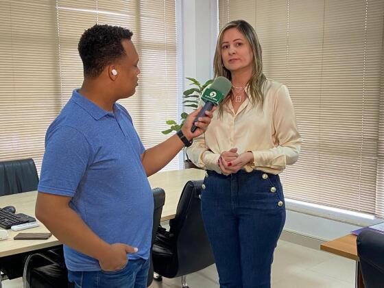 Repórter Caio Cordeiro durante entrevista com a interventora da saúde de Cuiabá, Danielle Pedroso Dias